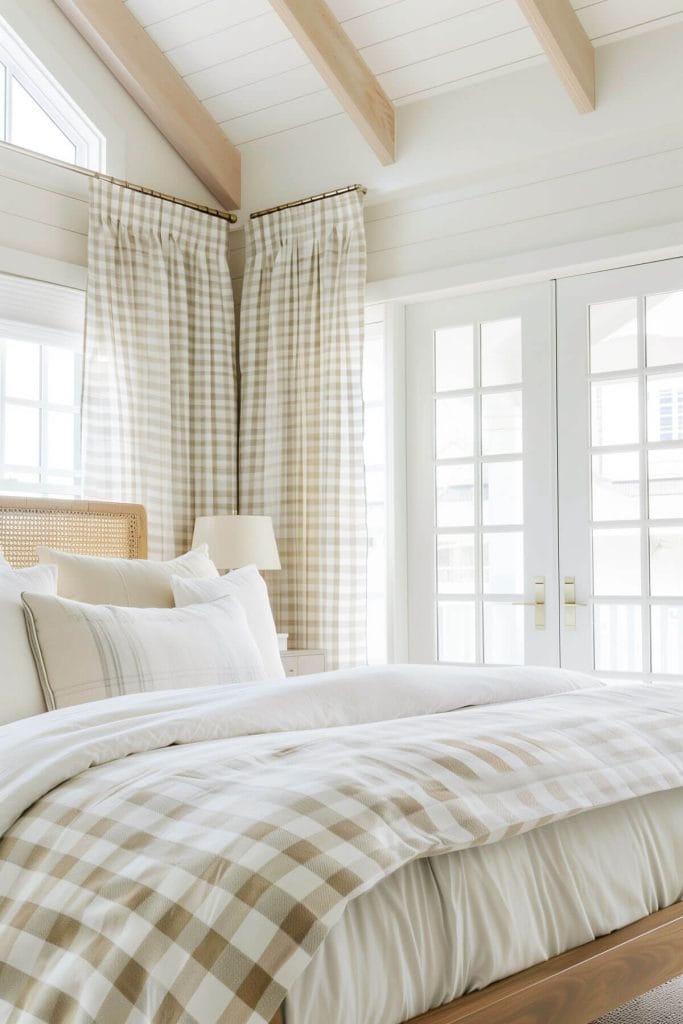 Gingham-patterned fabrics used for pillows, curtains, and tablecloths adding a country-inspired look to a bedroom.