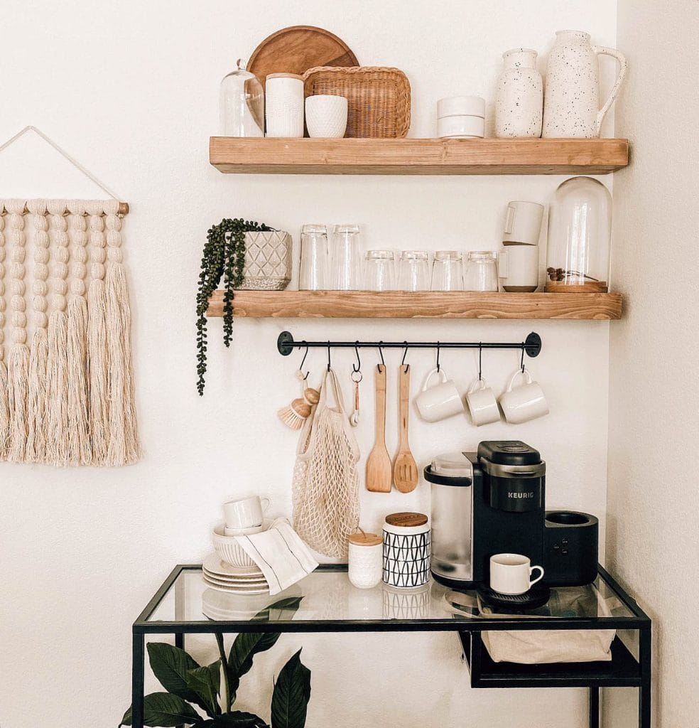 Farmhouse coffee bar with wicker baskets, chalkboard sign, vintage milk can, white cabinetry, and natural textures.