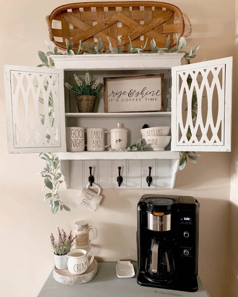 Adorable cabinet beverage nook with organized shelves and cozy coffee setup.