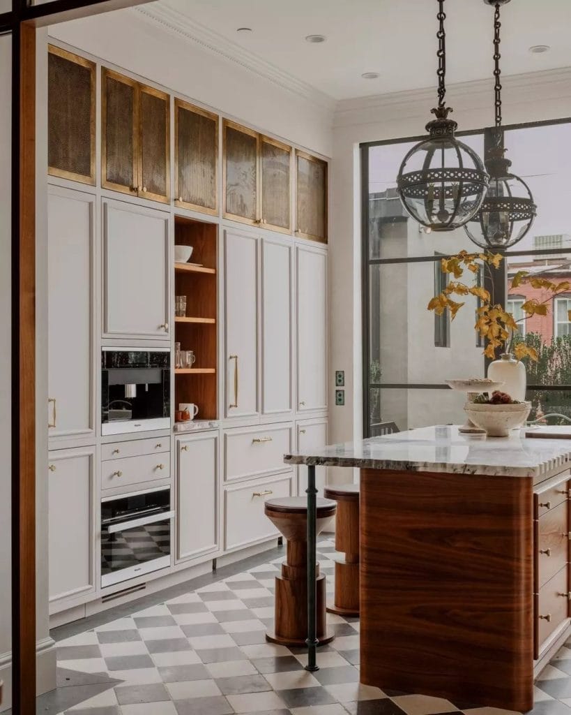 Built-in coffee station blending with kitchen cabinetry, hidden appliances, brass hardware, and marble countertops.