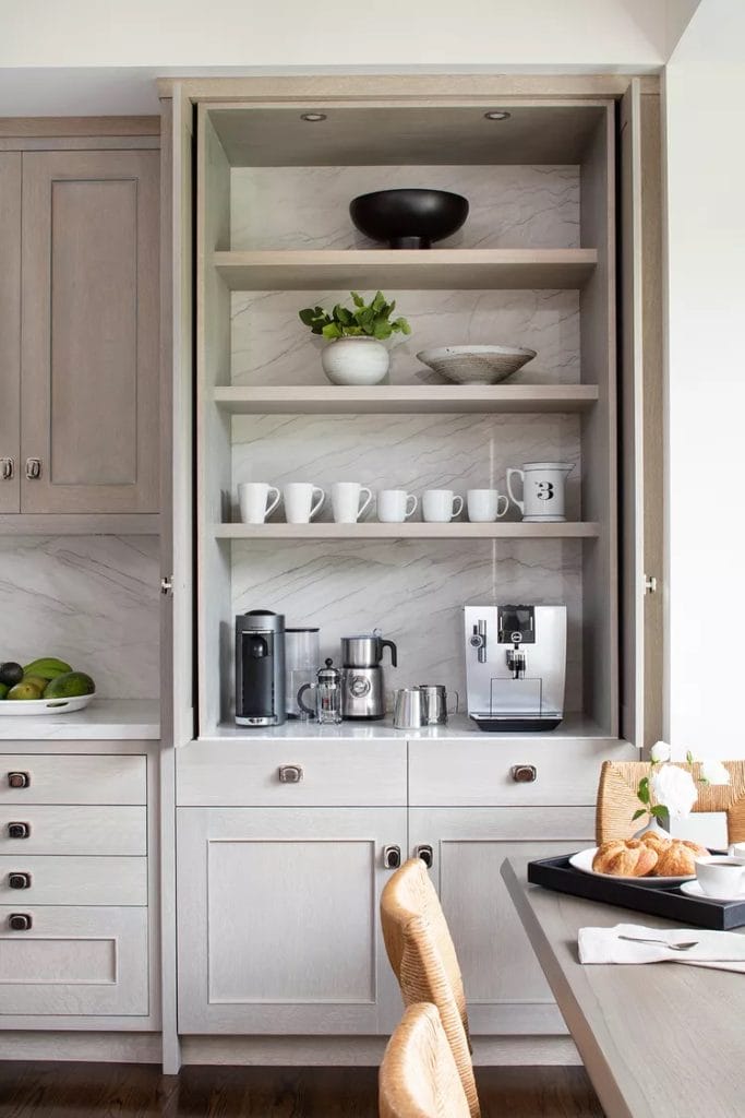 Sleek, modern greige coffee bar with integrated shelving, neutral color scheme, and subtle decorative pieces.