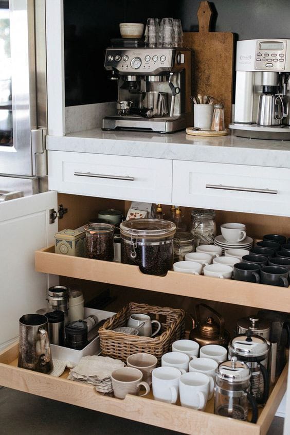 An organized coffee station with pull-out drawers and ample storage for coffee essentials.