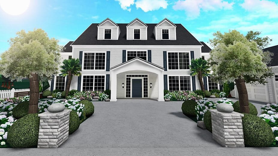 A grand colonial-style mansion with white siding, large windows, and a beautifully manicured garden, perfect for summer gatherings.