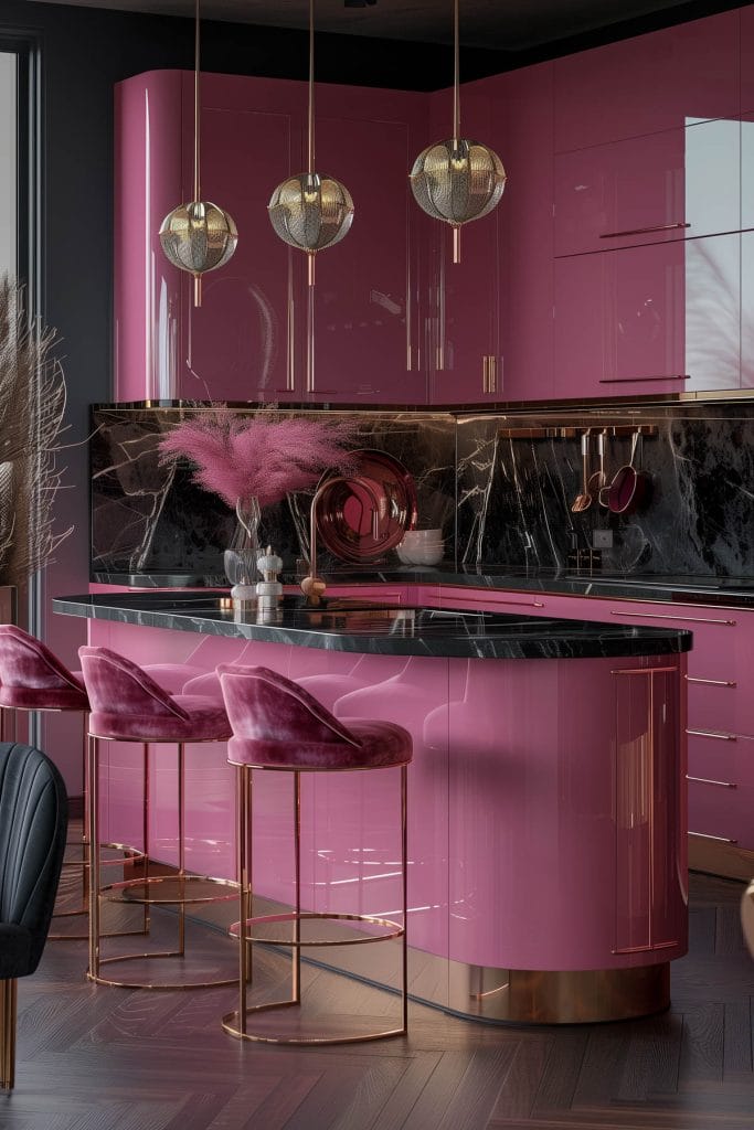 A luxurious retro luxe kitchen with high-gloss pink cabinetry, black marble countertops, and polished brass fixtures. The design includes statement pendant lighting and velvet bar stools.