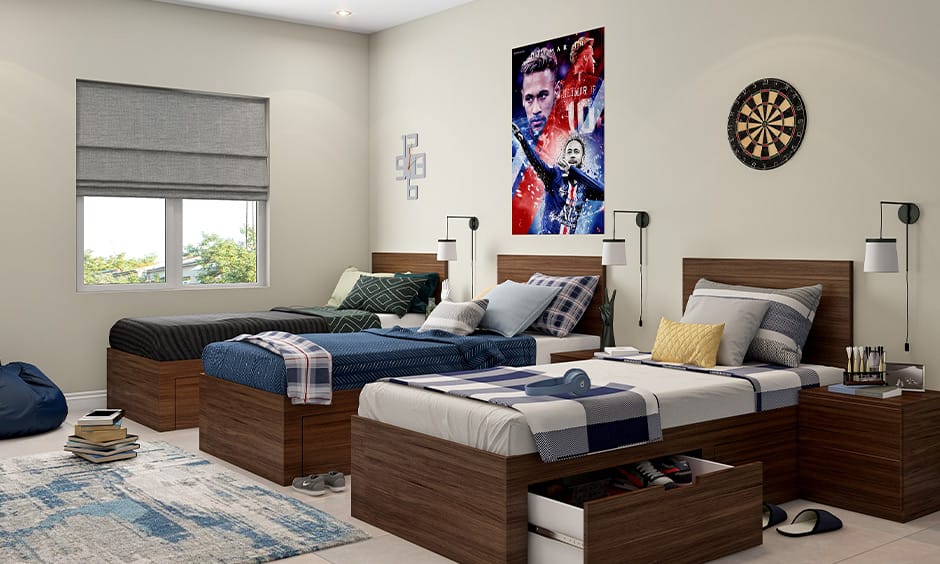 Dorm room with three beds, featuring individual study areas and blue and gray decor.