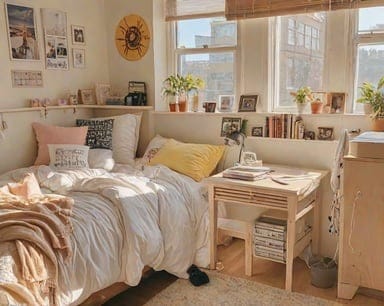 Room with a cozy bed, neutral tones, pops of yellow, plants, and personal photos.