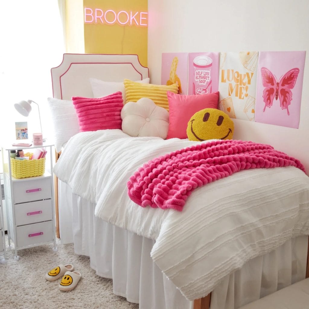 Room with twin beds, neon signs, yellow and pink accents, and colorful decor.