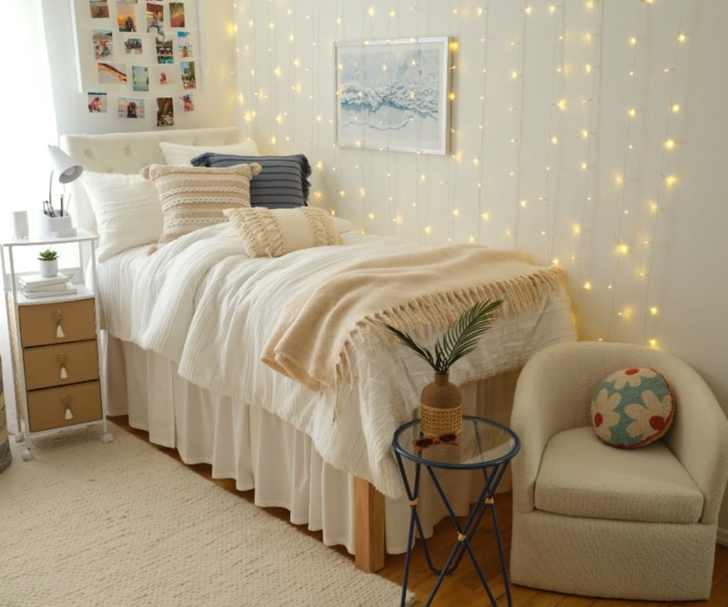 Bedroom with fairy lights, cozy bedding, and a small armchair.