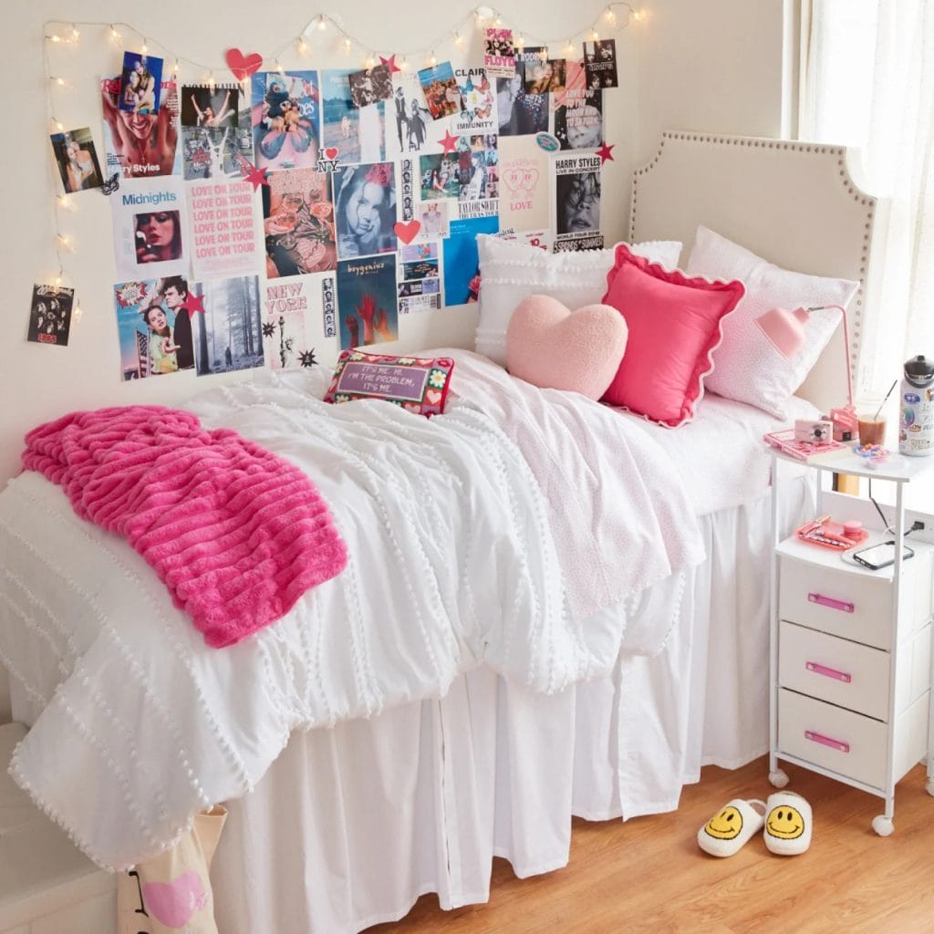 Vibrant room with bold pink accents, collage of posters, photos, cozy bed, and string lights.