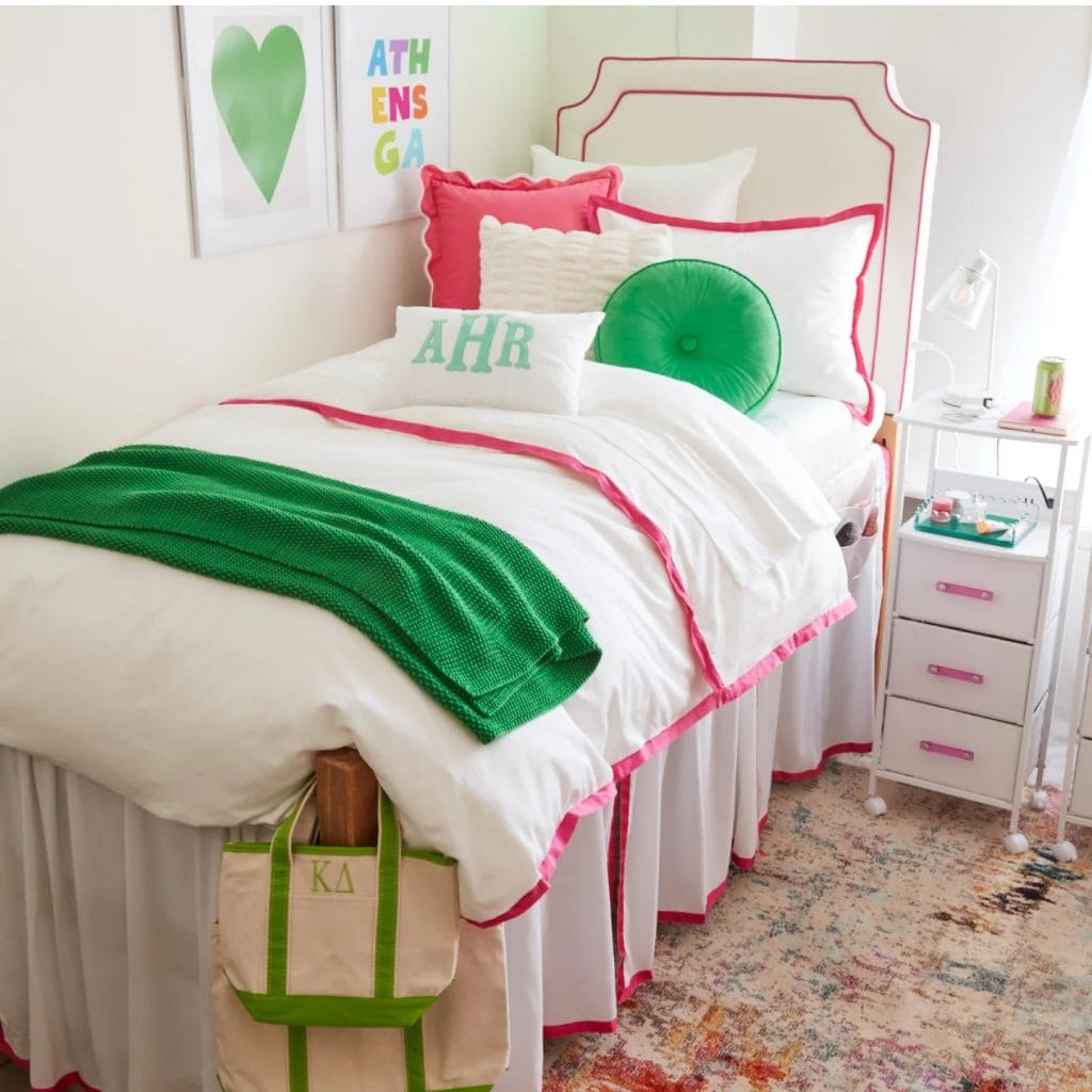 Cheerful room with bright green and pink bedding, monogrammed pillows, and matching decor elements.