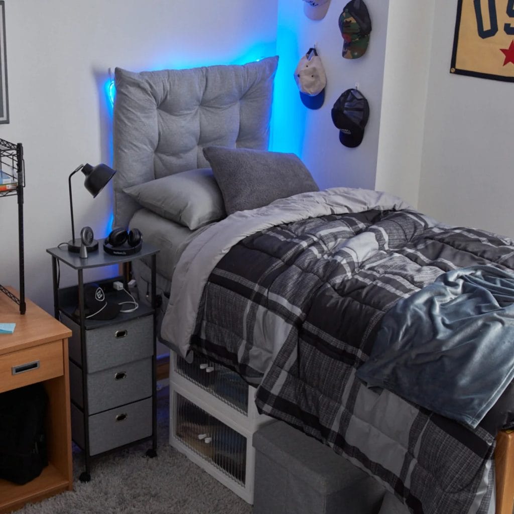 Room with a modern bed setup, blue LED lights, grey tones, and organized layout.