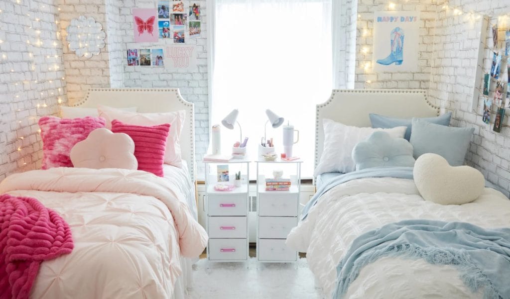 A bedroom with one side decorated in pink and the other in blue, featuring plush pillows, cozy throws, and matching bedding.