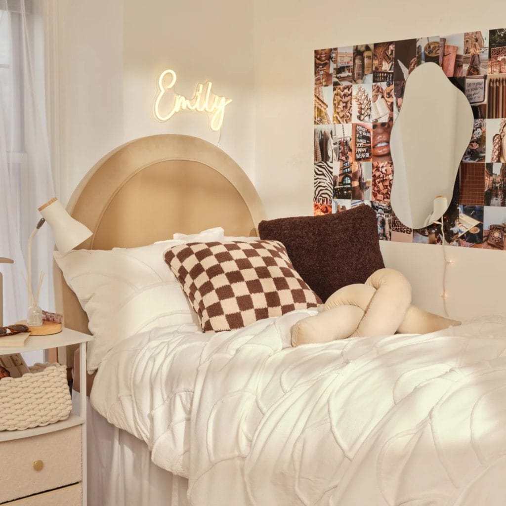 A chic room with a beige headboard, personalized neon sign, white bedding, and a photo collage on the wall.