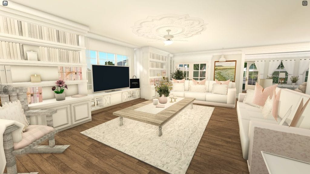 Bright and airy Bloxburg living room with white walls, light wooden floors, and a large sectional sofa.