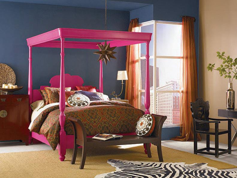 Bold teen bedroom with a bright pink canopy bed, dark walls, and eclectic decor.