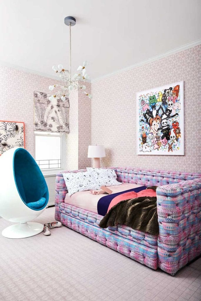 Playful bedroom with a colorful daybed, modern art, and a statement chandelier.