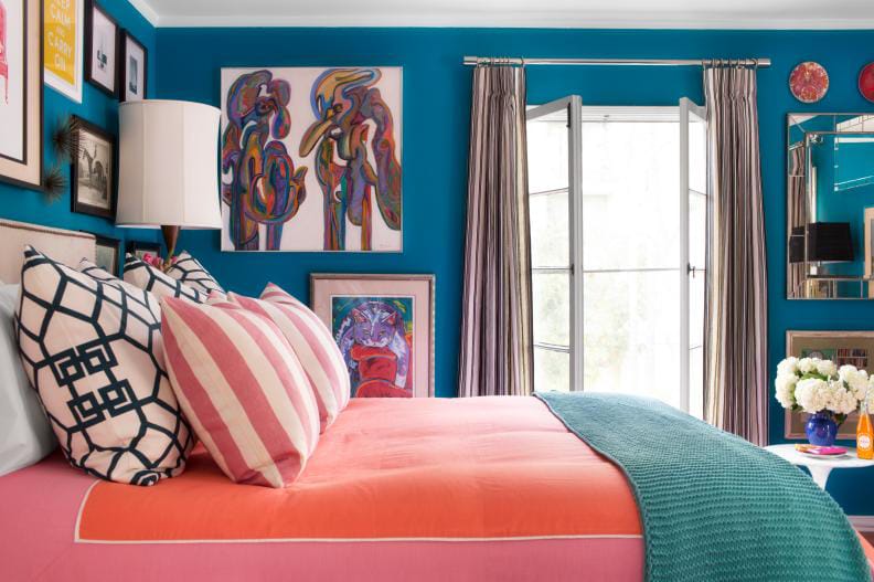 Colorful teen bedroom with teal walls, coral bedding, and vibrant wall art.