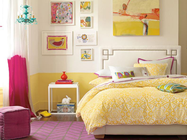 Bright teen bedroom with yellow and pink decor, colorful artwork, and patterned bedding.