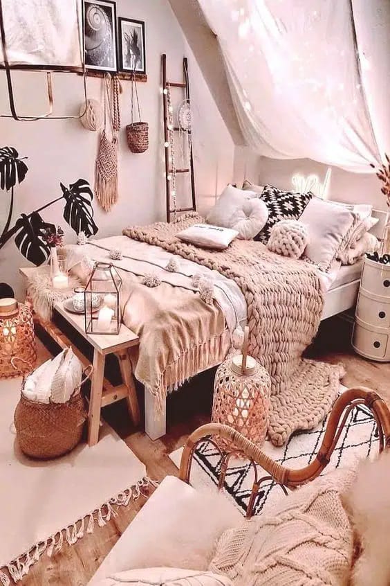 Boho chic bedroom with chunky knit blankets, decorative pillows, and soft lighting.