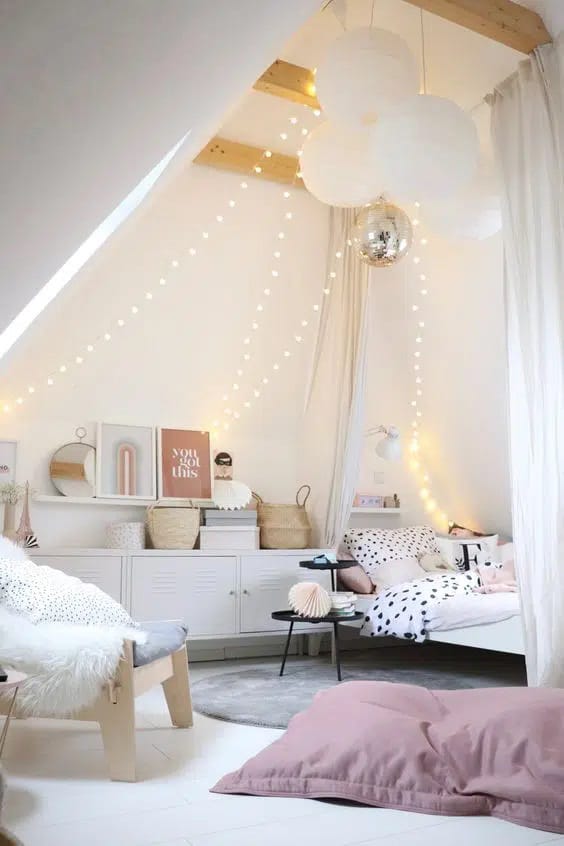 Loft bedroom with string lights and cozy seating.