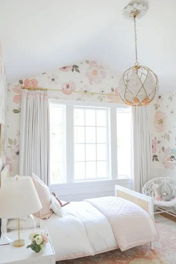 Bright bedroom with floral wallpaper and white furniture.