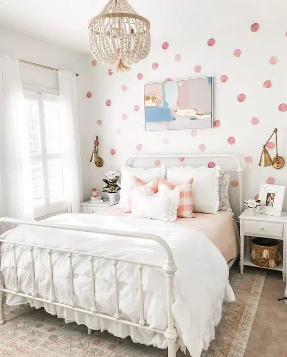 Bedroom with pink polka dot wall design and white bedding.