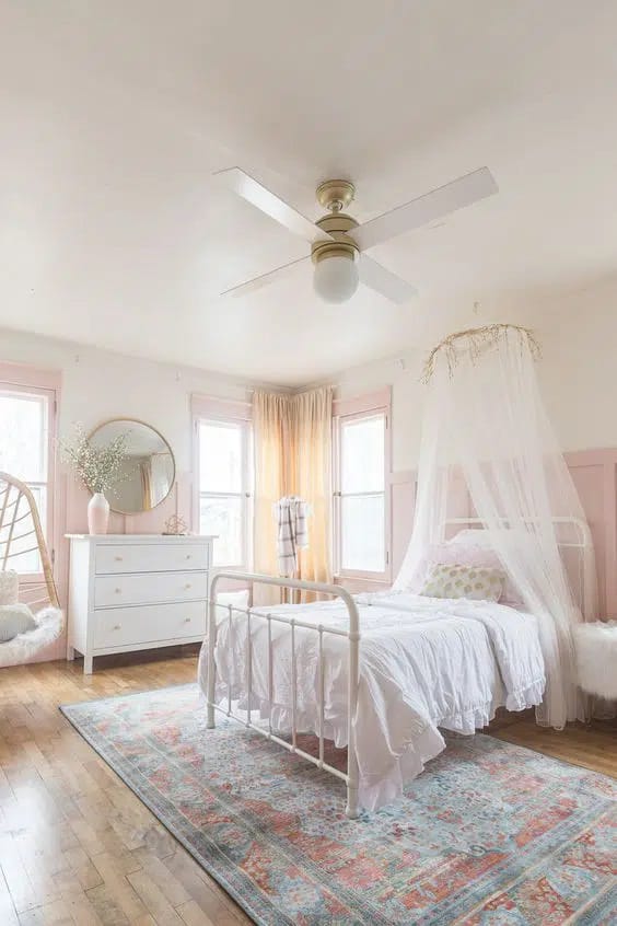 Bedroom with canopy bed and soft pastel colors.