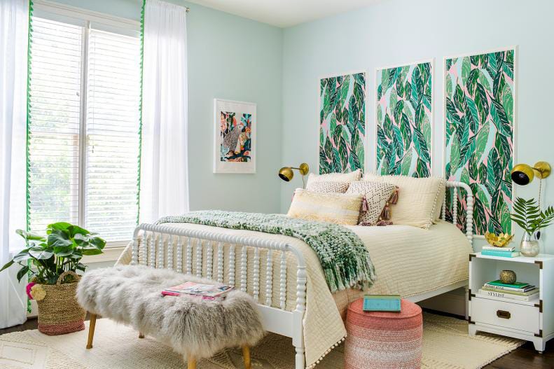 Tropical-themed teen bedroom with leafy wall art, white bed frame, and fur accents.