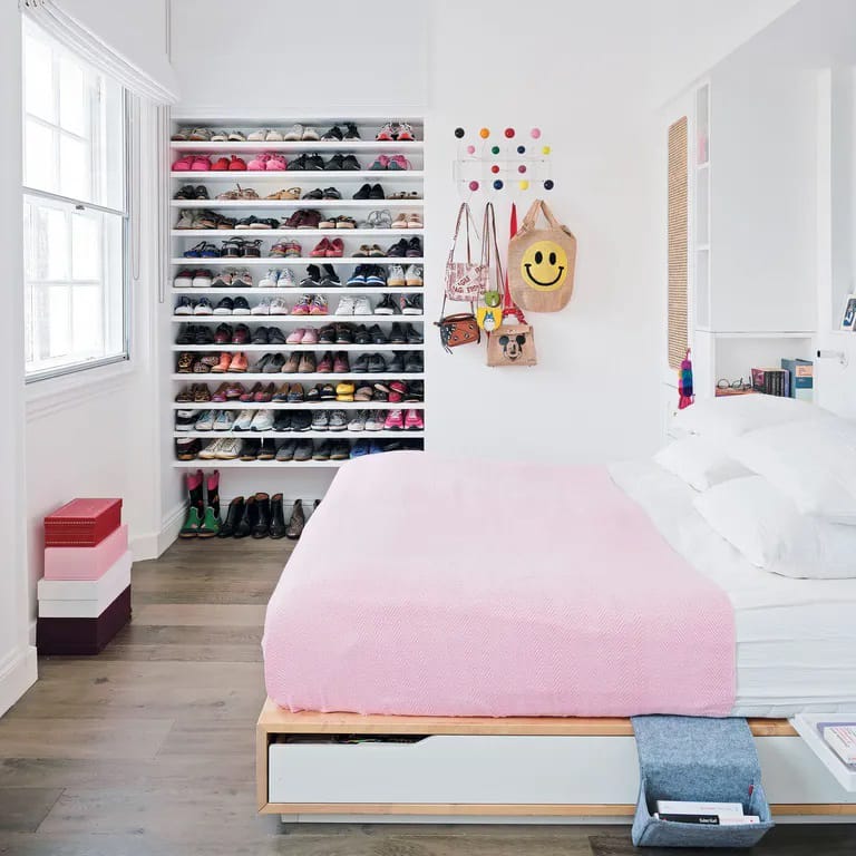 A clean, organized space with a large shoe display and pink accents.