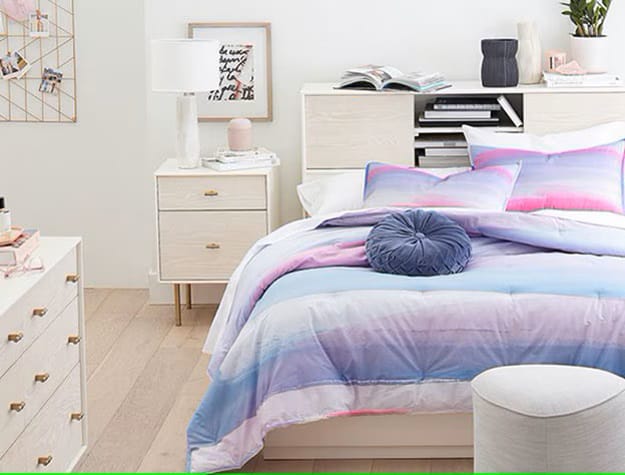 A teen bedroom featuring pastel ombre bedding, minimalist white furniture, and a serene ambiance.