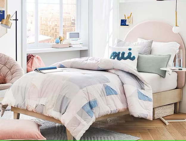 A modern teen bedroom with geometric bedding, minimalist furniture, and simple decorative touches.