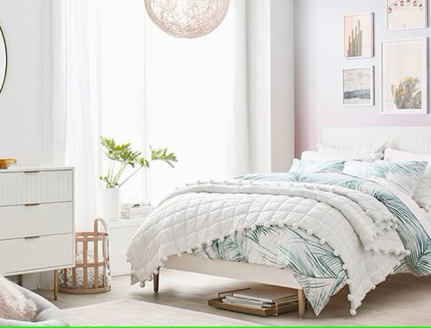 A bedroom with palm leaf-patterned bedding, a woven basket, and bright, natural light.