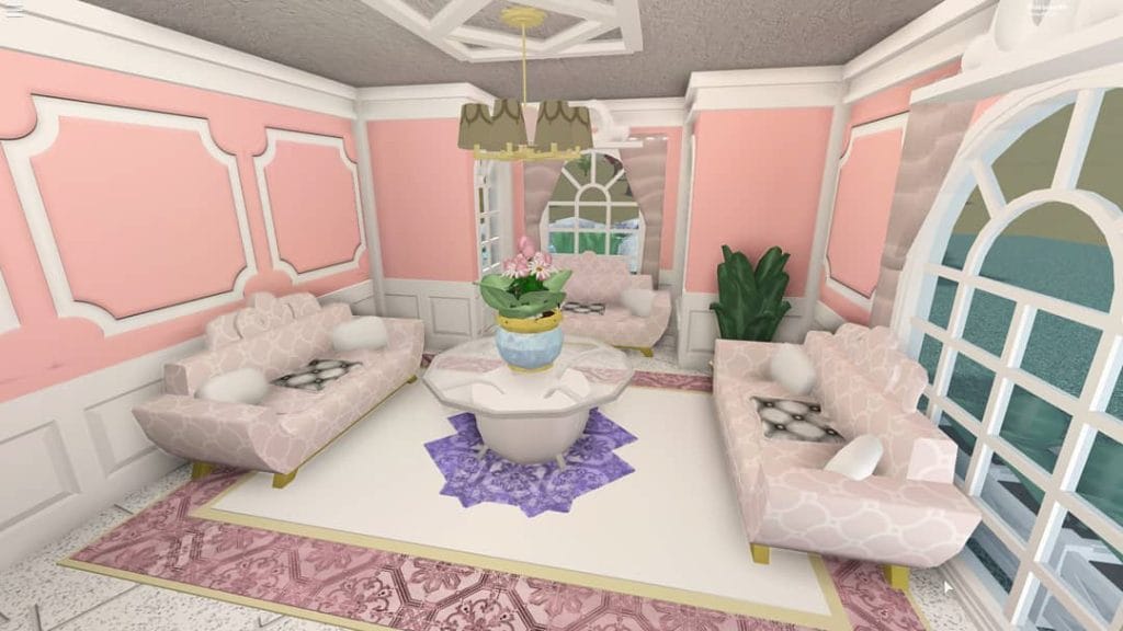 Bloxburg living room with pink and white decor, ornate moldings, and pink sofas.