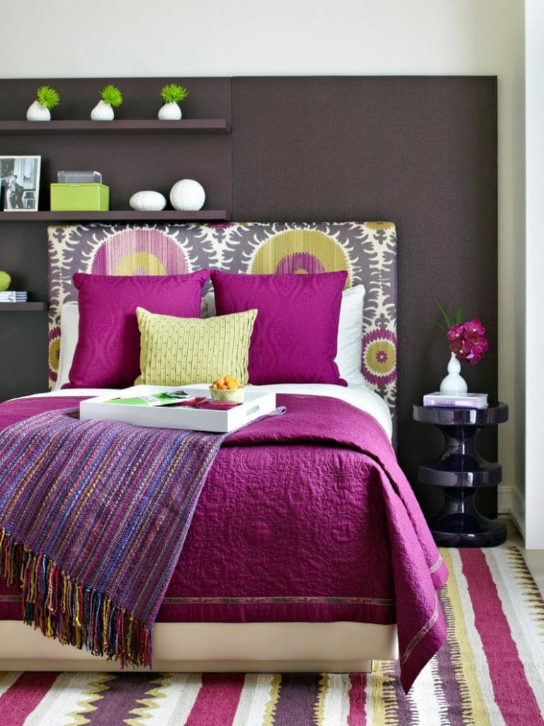 Vibrant teen bedroom with magenta bedding, bold patterns, and modern decor.