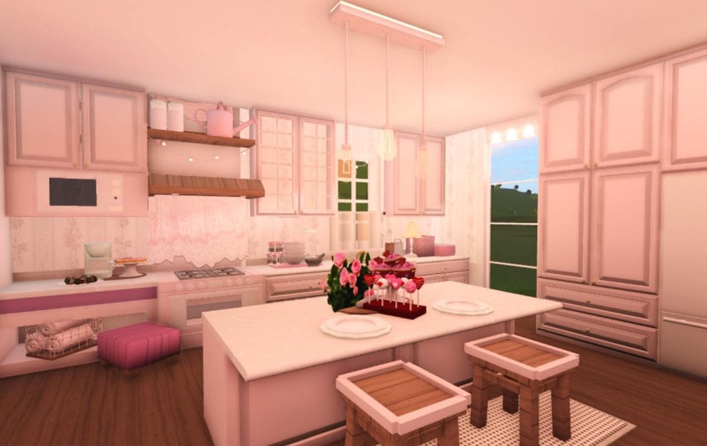 A romantic Bloxburg kitchen with soft pink hues, delicate lighting, and cozy decor.