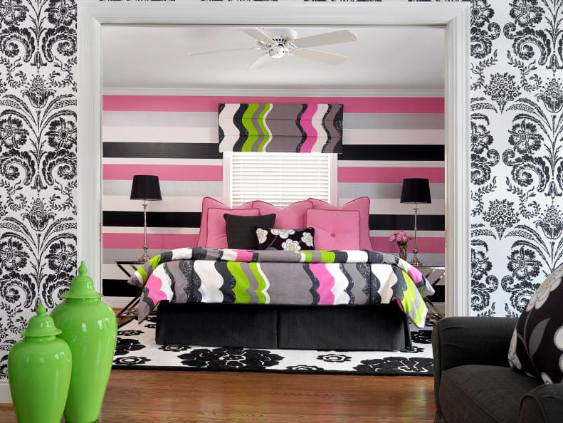 Teen bedroom with black, white, and pink striped patterns, bold wallpaper, and bright green accents.