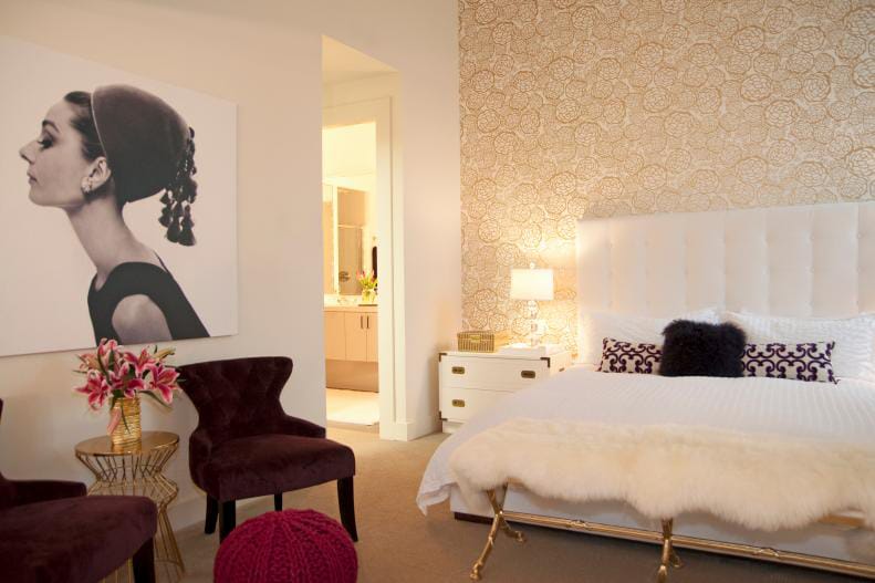 Classic glam teen bedroom with a tufted white headboard, gold wallpaper, and velvet seating.