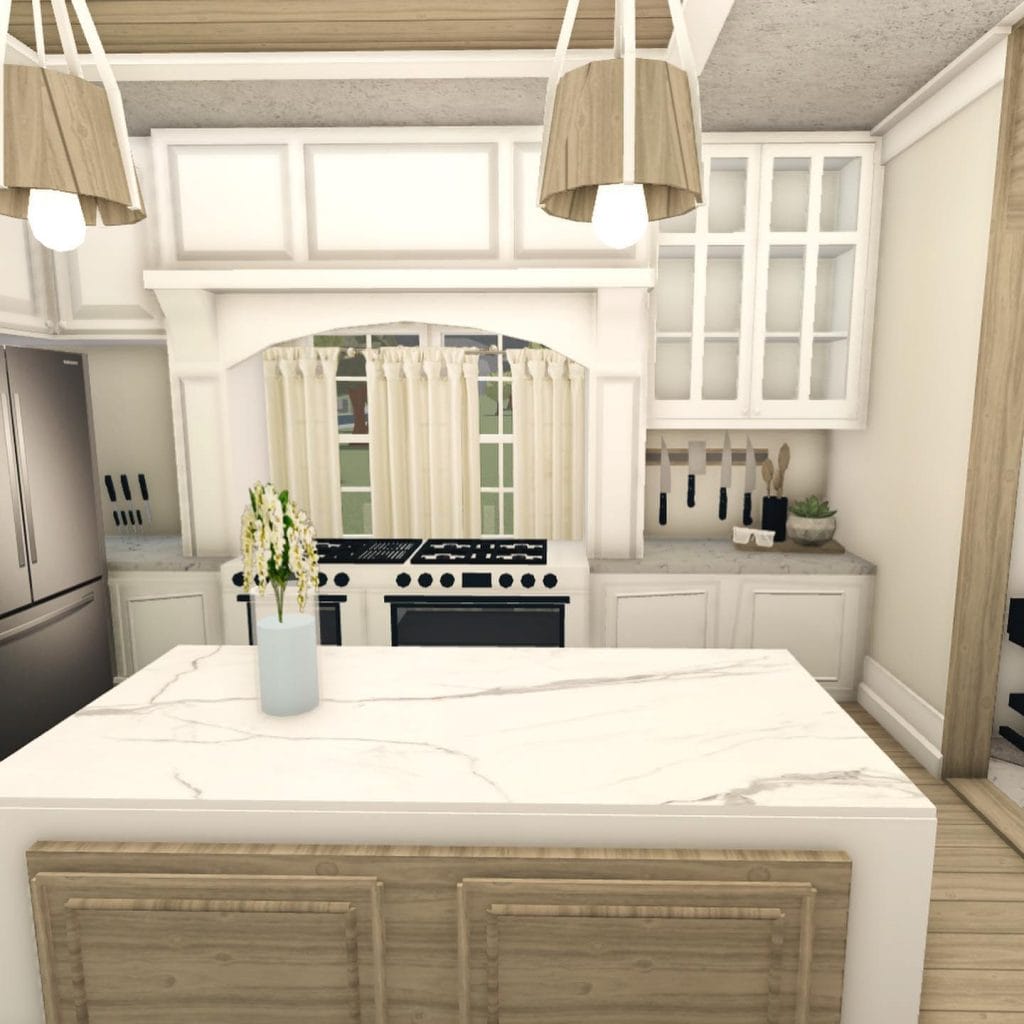 A Bloxburg kitchen with a central island, marble countertops, and a blend of light wood and white finishes.