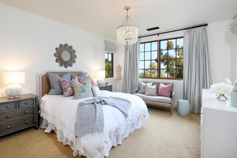 Elegant teen bedroom with neutral decor, chandelier, and cozy window seating.