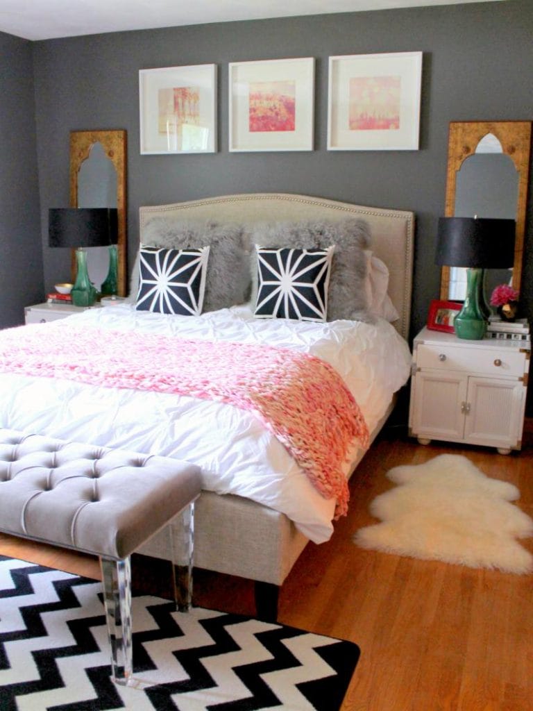 Bold teen bedroom with black, white, and pink accents, patterned decor, and striking artwork.