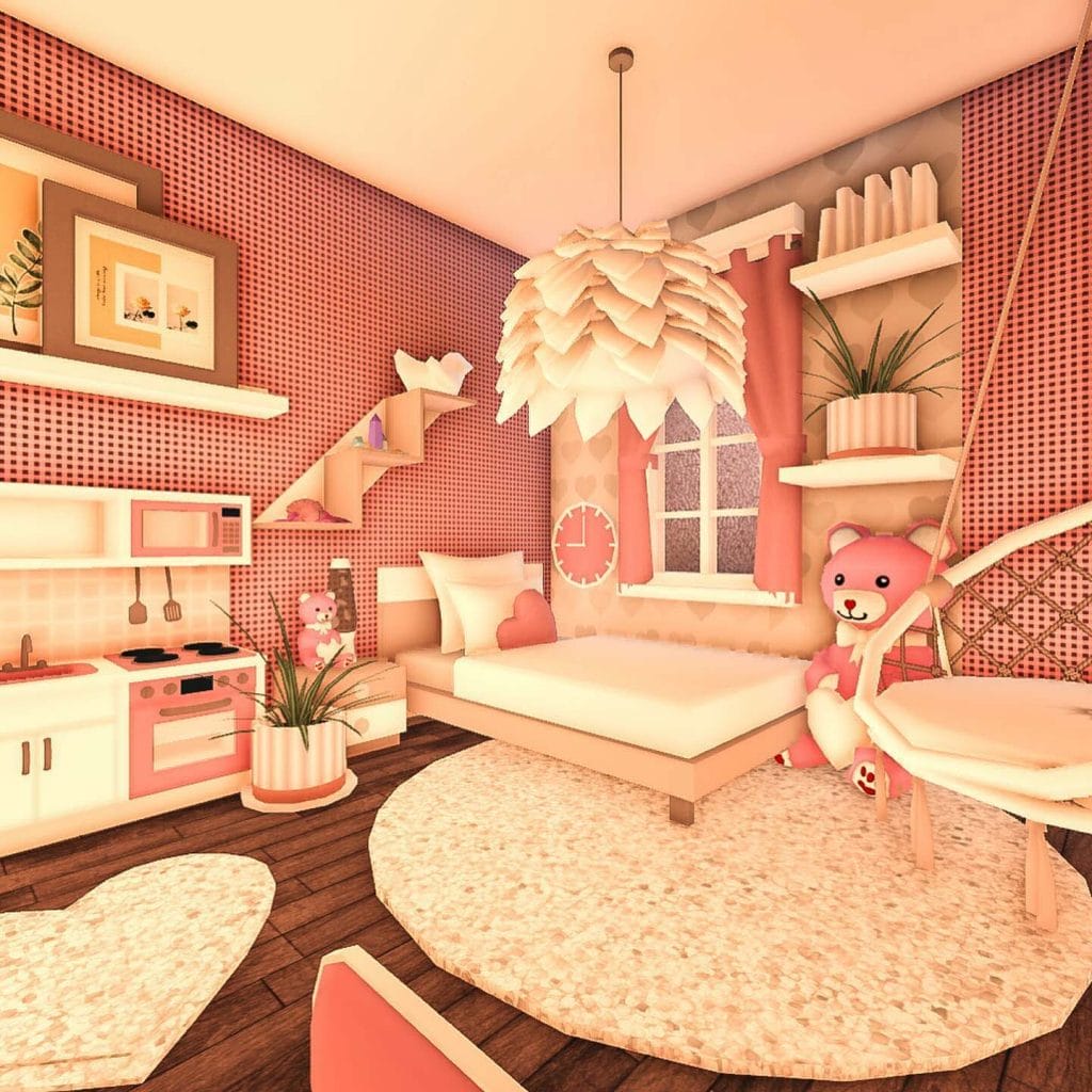 A playful kid's bedroom with a pink and white color scheme, featuring a faux kitchen set, cozy reading nook, and round rug.