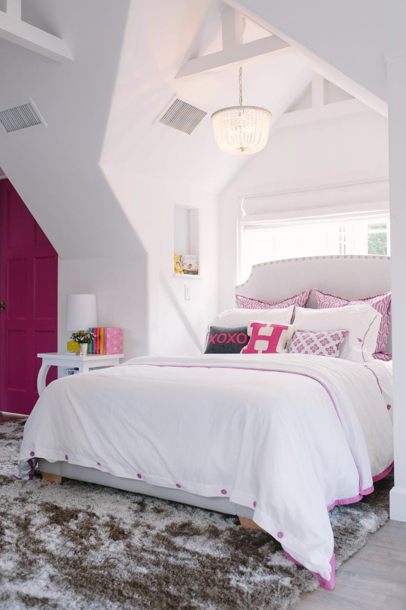 Cozy teen bedroom with vaulted ceiling, white and pink decor, and a chandelier.