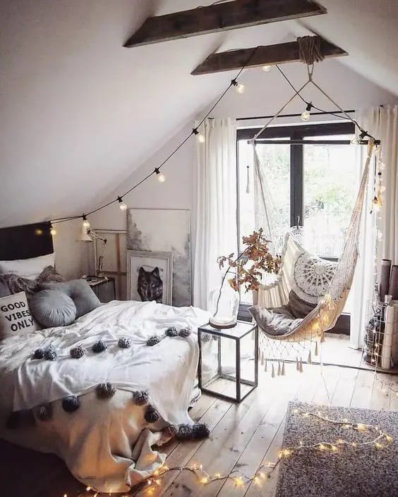 Boho chic teen bedroom with a hammock chair, string lights, and rustic wooden beams.