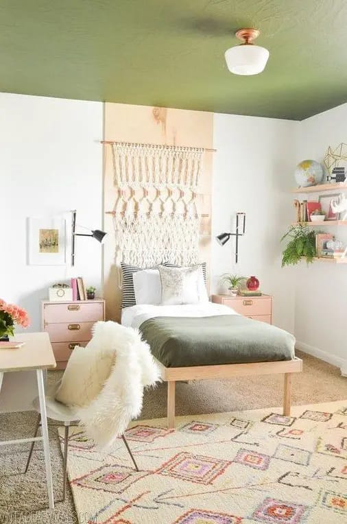 Modern teen bedroom with macrame decor, green ceiling, and minimalist furniture.