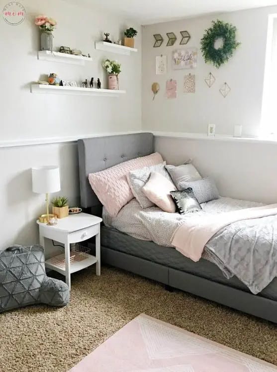 Teen bedroom with a gray upholstered bed, pink bedding, and pastel decor.