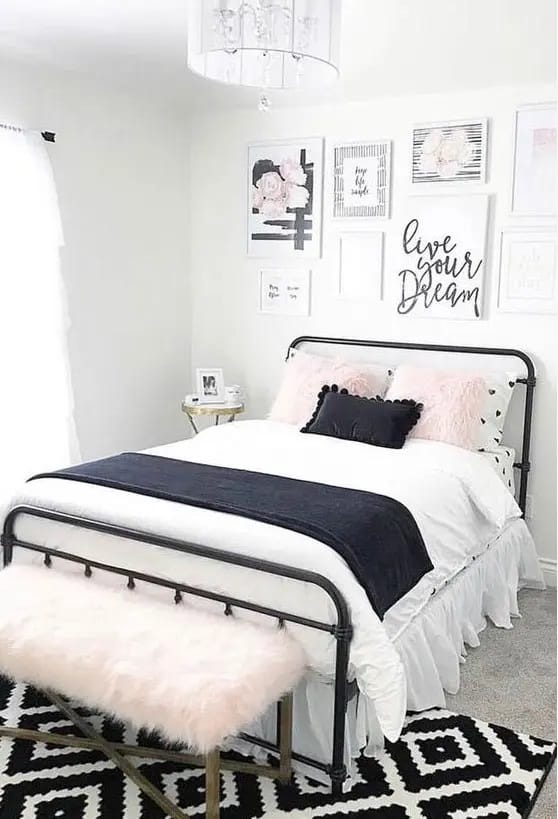 Teen bedroom with black and white decor, pink accent pillows, and inspirational wall art.