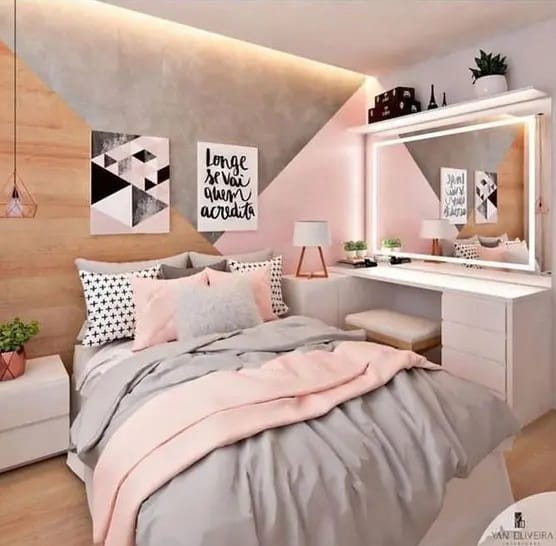 Teen bedroom with pink bedding, geometric accent wall, and a cozy vanity area.