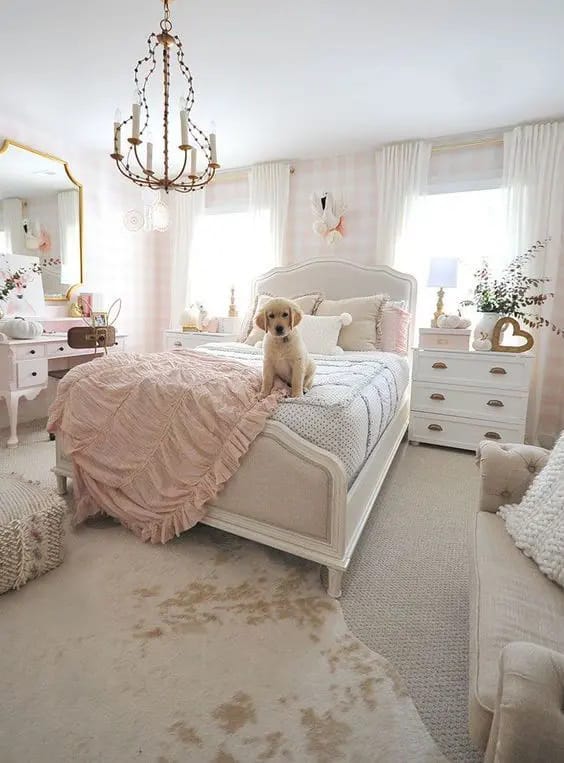 Elegant teen bedroom with plush bedding, pink accents, and a chandelier.