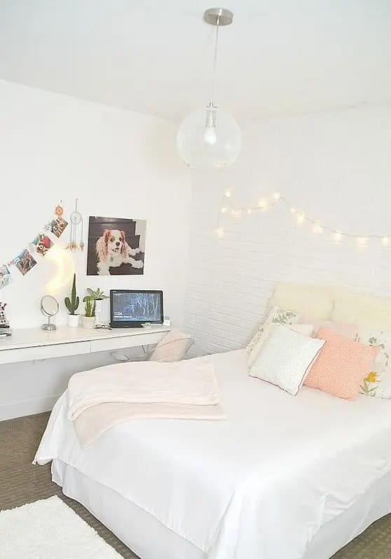 Simple and bright teen bedroom with string lights, workspace, and pastel accents.