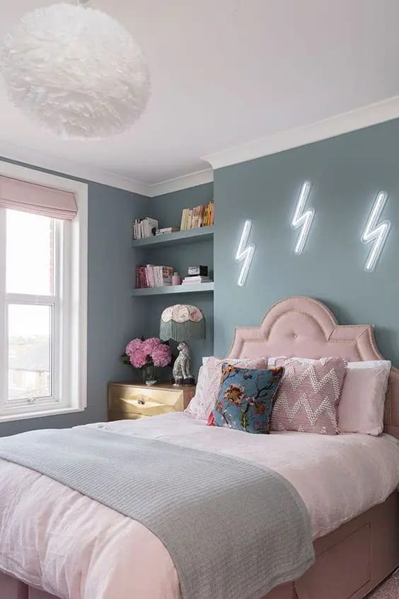 Chic teen bedroom with teal wall, neon wall art, and pastel bedding.